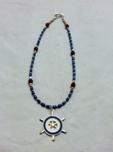 Nautical pendant with accents of silver, dark red, and blue pearl beads.